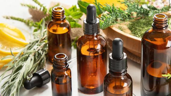 Bottles of essential oils alongside plants