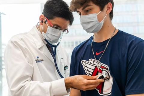 Doctor uses stethoscope on teen boy