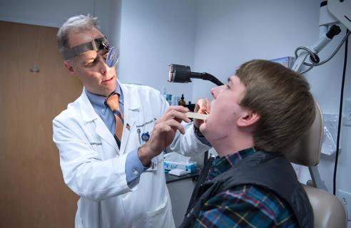 Doctor performing oral exam on patient