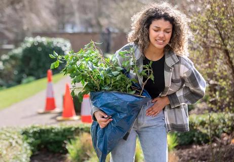 Woman gardening while experiencing endometriosis pain in pelvic area.