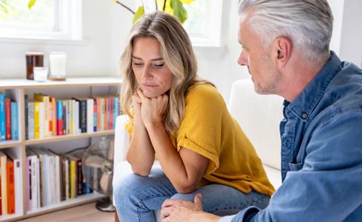 Couple sitting couch looking sad