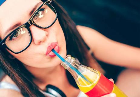 Young woman sipping soda through a straw
