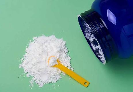 taurine powder with spoon next to bottle