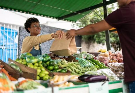 Person buying vegetables from a farmer's market.