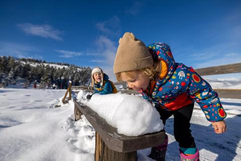 two kids eating snow outside