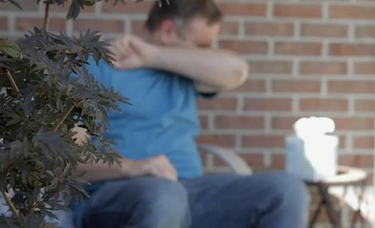 Man sneezing outside