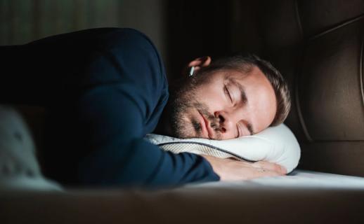 Person wearing earbuds while asleep in bed