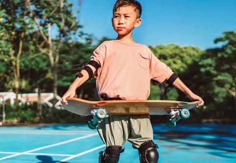 child with skateboard alone at skatepark