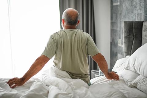 Older person getting out of bed in the morning