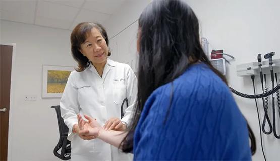 doctor taking pulse of a woman in an exam room