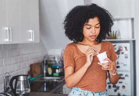 woman eating greek yogurt because of digestive disorder