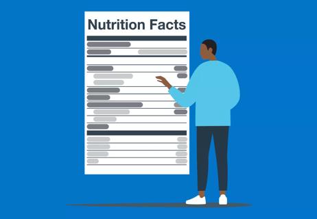 Person standing in front of oversized nutrition label, reading it
