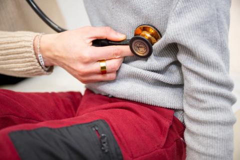 clinician holds stethoscope on child's chest
