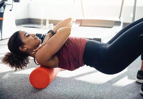 Person rolling upper back on foam roller.