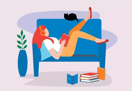 person lying on couch with headphones and reading a book alone