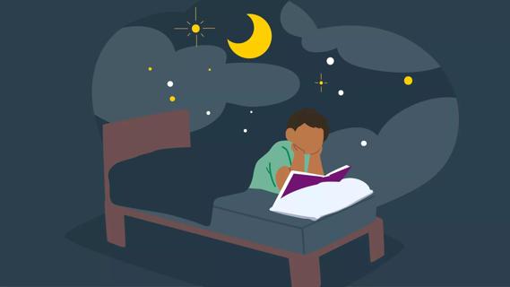 Young child in bed reading at night