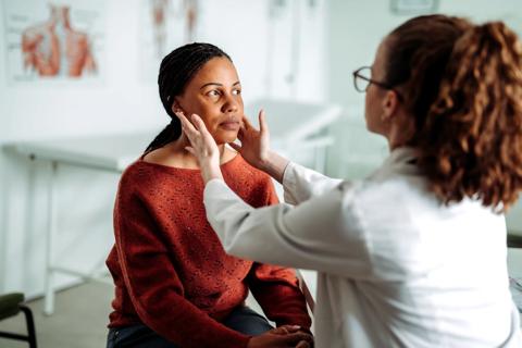 Healthcare provider feeling lymph nodes along jaw line