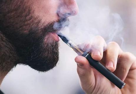Closeup of a person smoking an e-cigarette.
