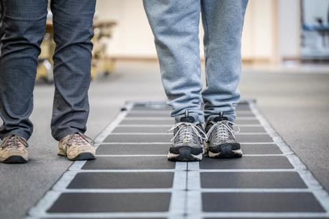 Legs of healthcare provider and patient during rehabilitation