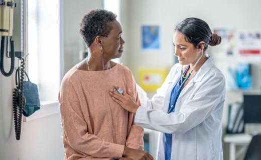 Healthcare provider listening to heart of an older patient