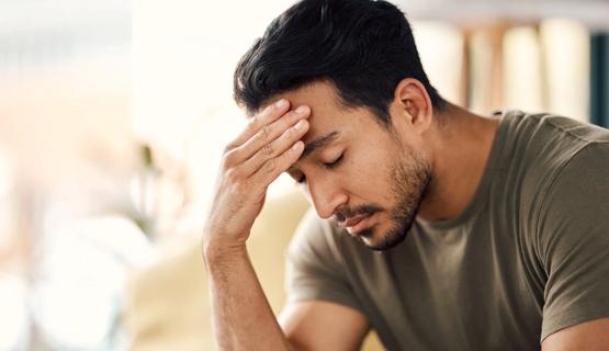 Tired man with head in hand, eyes closed