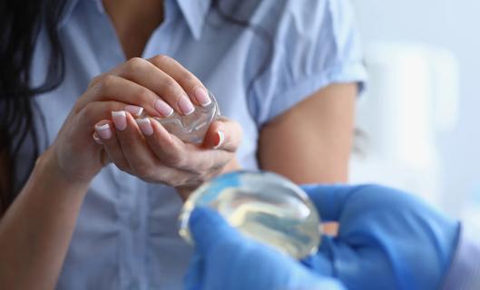 Patient holding a breast implant, seeing what it feels like