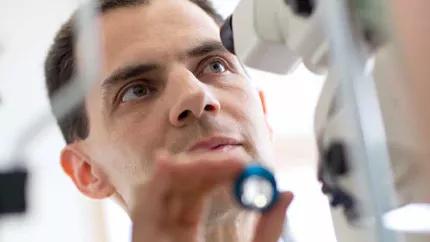 Ophthalmologist looking through a Phoroptor to examine a patient.