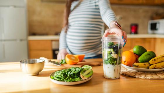 Pregnant person making a healthy smoothie