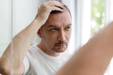 Person checking out their hairline and hair in a mirror