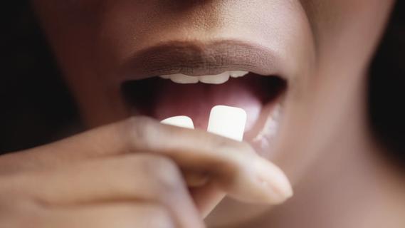 Person putting gum in their mouth