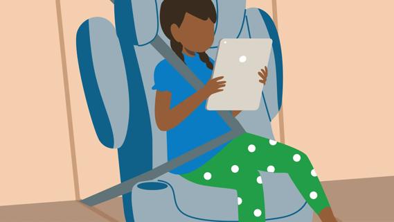 Older child sitting in car booster seat, using tablet