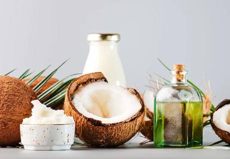 Half of a coconut next to bottles and bowls