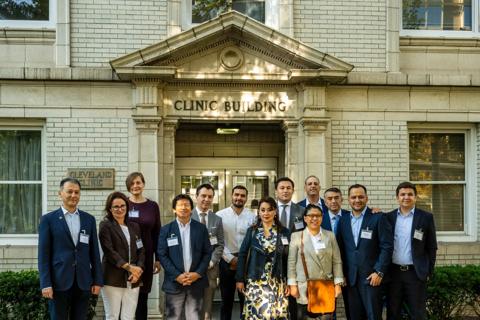 A group of people standing in front of a historic Cleveland Clinic building