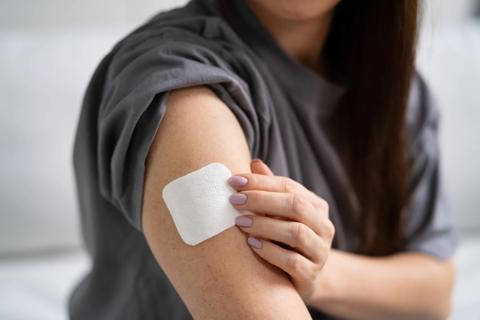 Person applying a health patch to their arm