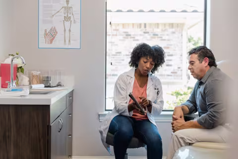 Healthcare provider showing a patient information on a medical tablet
