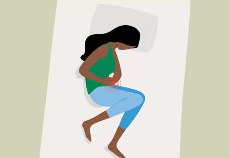 An illustration of a person lying in bed holding their stomach in pain