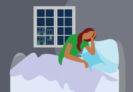 Upset woman sitting in bed at night.
