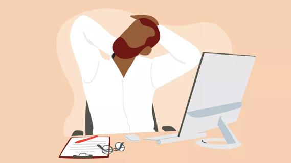 Person stretching neck at work desk in front of monitor