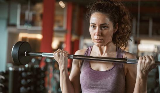 Person lifting a barbell in a gym