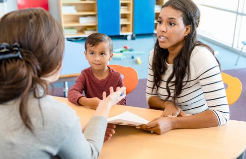 Mom, child and teacher talk one-on-one at school