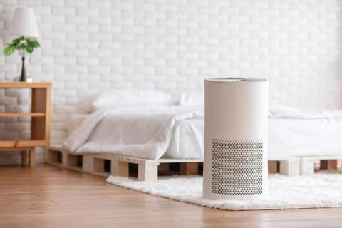 Air purifier in cozy white bedroom