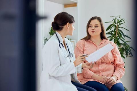 Healthcare provider talking with patient with overweight in office