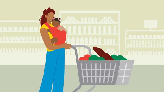 Caregiver holding baby in babysling while pushing shopping cart in grocery store