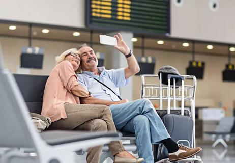 Older couple taking selfie at airport