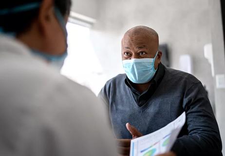 Elderly man talking with doctor at his appointment.