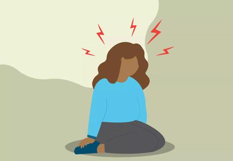 person sitting with migraine pains and visible aura