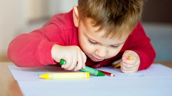 Young child coloring with crayons