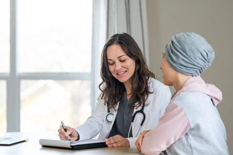 Female in hair wrap talking with healthcare provider in office