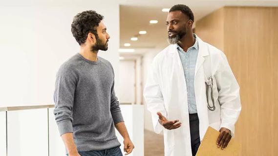 adult male in 20s talking with adult male doctor