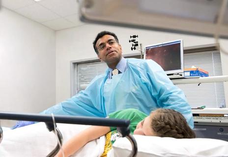 Dr. Radhakrishnan with patient giving clinical exam